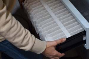 Woman is replacing furnace filter at home