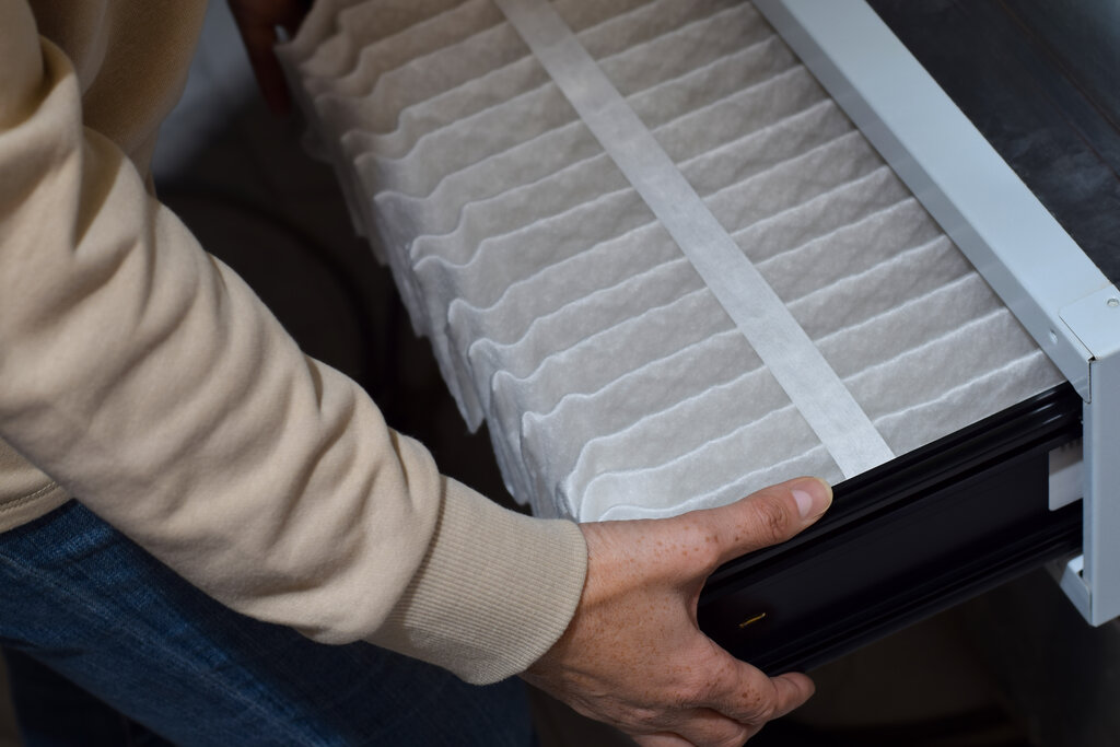 Woman is replacing furnace filter at home